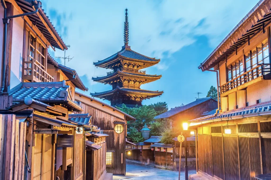 Rue traditionnelle de Kyoto au coucher du soleil avec pagode japonaise Rue traditionnelle du quartier Higashiyama à Kyoto avec maisons en bois et pagode japonaise illuminée au coucher du soleil dans une ambiance authentique du Japon.