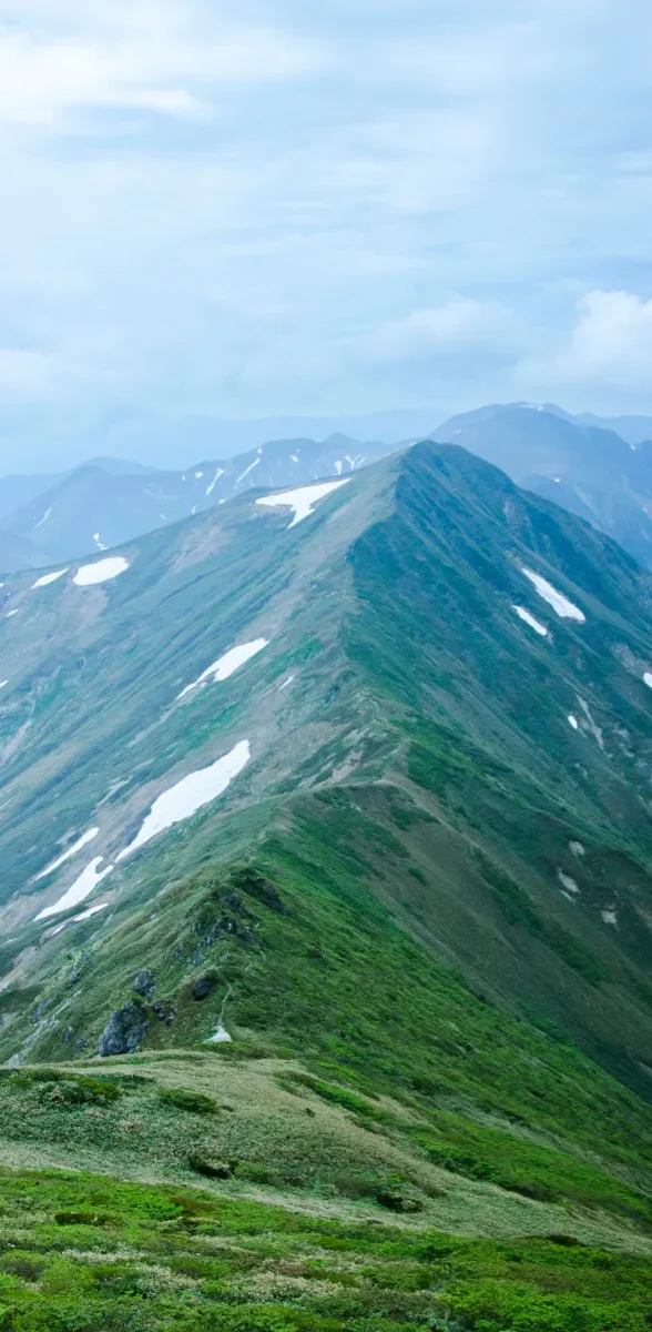 Vue panoramique du mont Tanigawa dans la préfecture de Gunma au Japon, avec ses longues crêtes montagneuses verdoyantes.