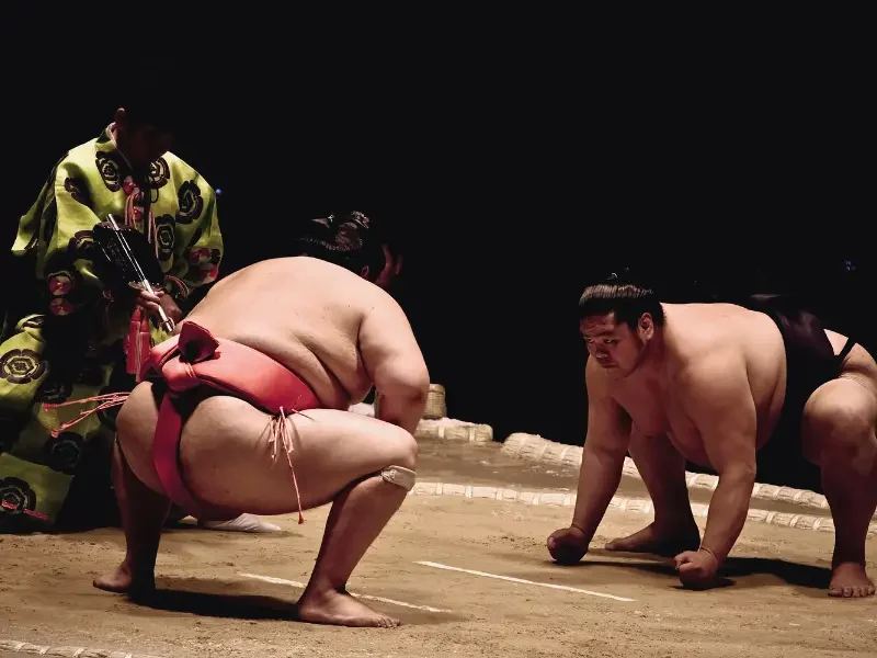 Assister à un tournoi de sumo – Une immersion au cœur de la tradition japonaise Combat de sumo au Japon avec lutteurs sur le ring lors d’un tournoi