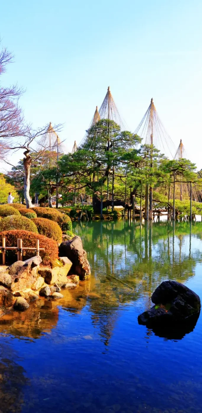 Jardin Kenroku-en à Kanazawa, l’un des plus beaux jardins du Japon Jardin Kenroku-en à Kanazawa avec étang, rochers et arbres traditionnels japonais