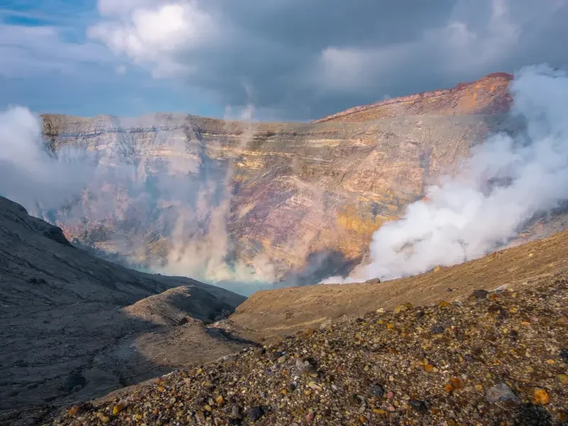 Explorez les volcans du Japon – Une expérience nature unique et saisissante Cratère volcanique au Japon avec fumées et paysages montagneux