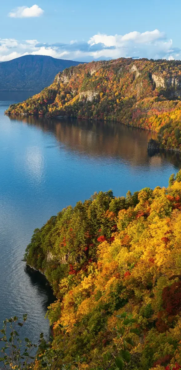 Lac Towada à Aomori entouré de forêts aux couleurs d’automne au Japon