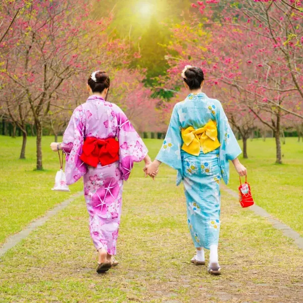 Deux voyageuses en kimono traditionnel se promenant dans un jardin japonais au printemps