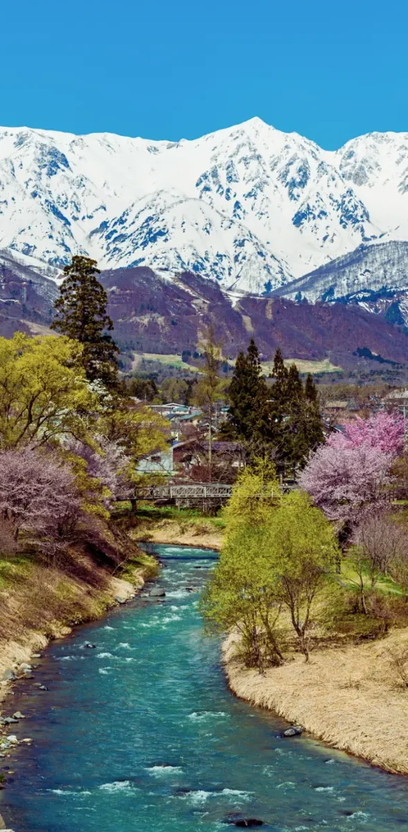 Alpes japonaises à Nagano avec rivière et montagnes enneigées Rivière traversant un paysage de Nagano avec montagnes enneigées des Alpes japonaises
