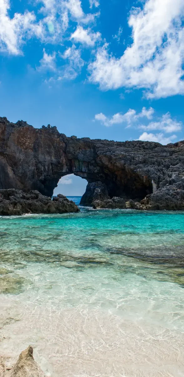 Plage d'Ogasawara au Japon avec arche rocheuse et eau turquoise Plage japonaise avec eau turquoise et arche rocheuse naturelle sous un ciel bleu