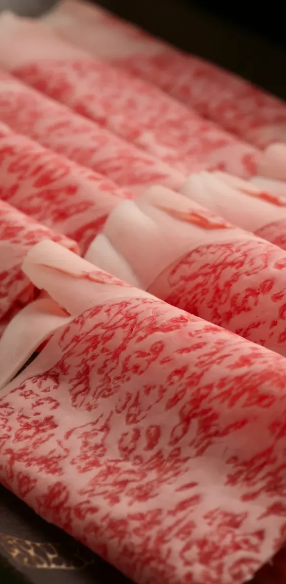 Bœuf de Miyazaki japonais au marbrage exceptionnel Tranches de bœuf de Miyazaki au Japon présentant un marbrage fin et fondant, spécialité gastronomique japonaise réputée pour sa qualité.