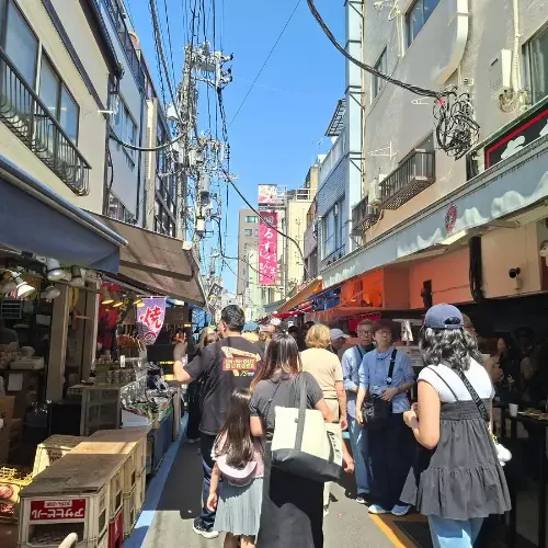 Allée animée d'un marché japonais avec commerces locaux, visiteurs et spécialités régionales