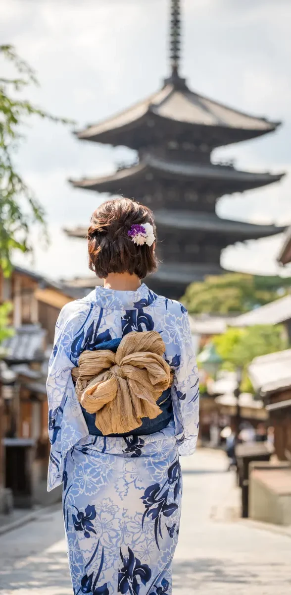 Kimono traditionnel dans les rues de Kyoto Femme portant un kimono traditionnel dans une rue historique de Kyoto avec pagode japonaise en arrière-plan.