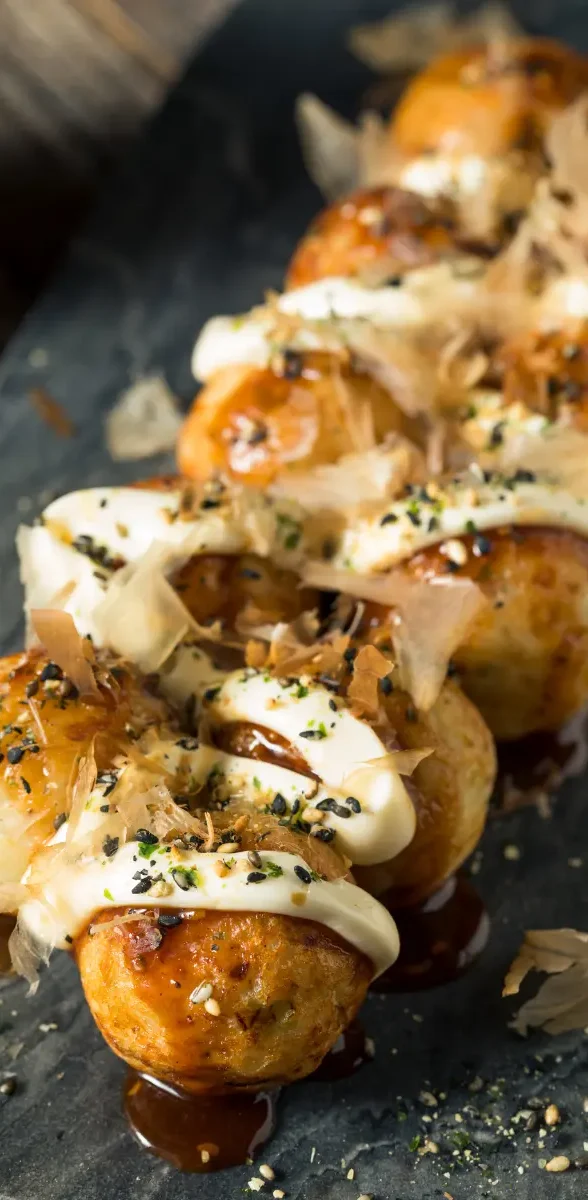 Takoyaki à Osaka, spécialité emblématique japonaise Takoyaki à Osaka avec sauce, mayonnaise et copeaux de bonite en street food japonaise
