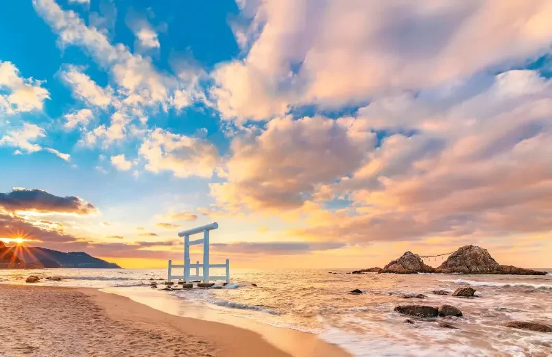 Torii face à la mer à Fukuoka Torii installé sur une plage de la préfecture de Fukuoka au coucher du soleil.