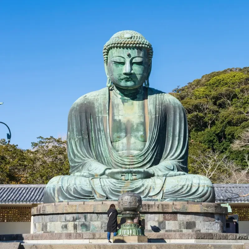 Kamakura entre temples et océan | Grand Bouddha du Japon | J’Go Japon Grand Bouddha de Kamakura devant les collines verdoyantes près de la côte japonaise