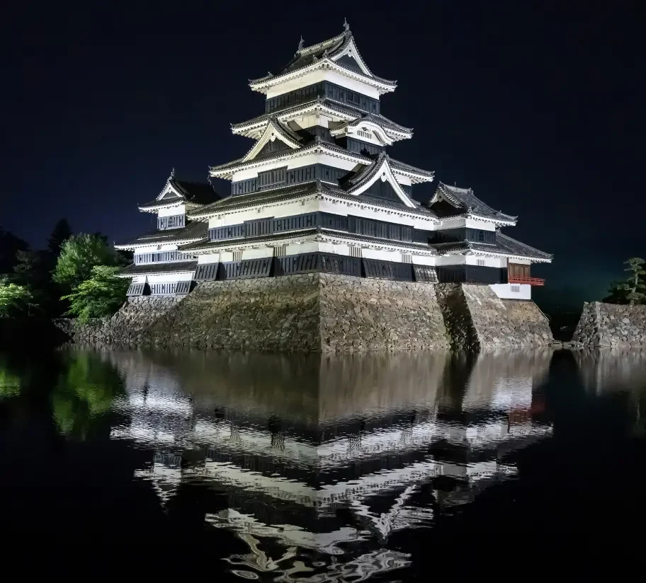 Château de Matsumoto de nuit Château de Matsumoto illuminé et reflété dans les douves.