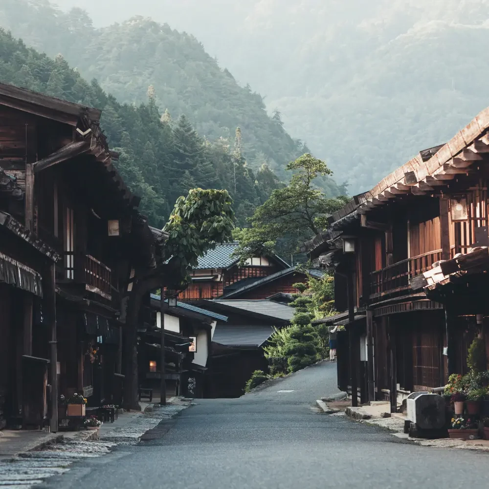 Village traditionnel japonais dans les Alpes japonaises Rue bordée de maisons traditionnelles japonaises en bois au cœur des Alpes japonaises, illustrant l'atmosphère authentique d'un ryokan