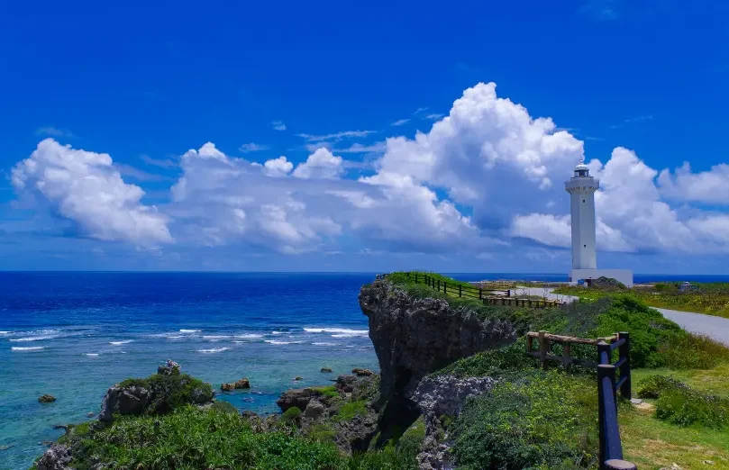 Phare blanc dominant la côte rocheuse et les eaux bleues de Miyako-jima.