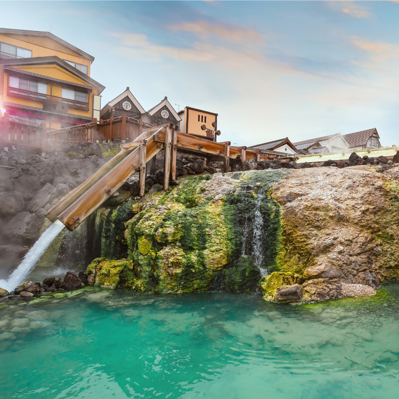 Détente en onsen – Une parenthèse bien-être au cœur du Japon Onsen japonais en extérieur avec source chaude naturelle et ryokan traditionnel