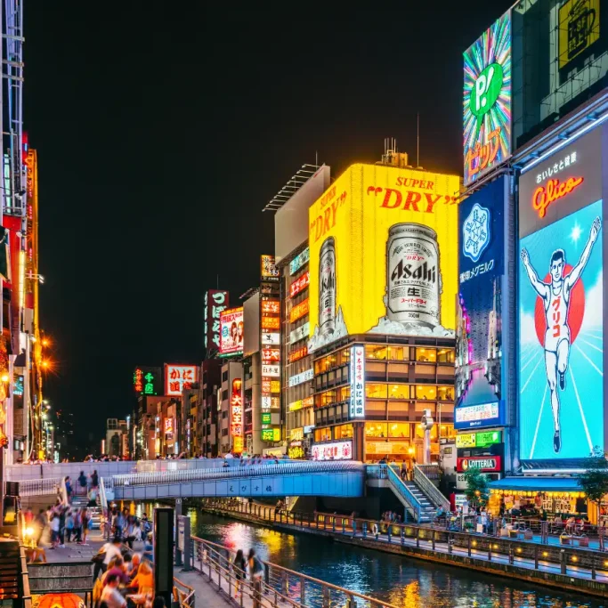 Quartier animé de Dotonbori à Osaka de nuit avec enseignes lumineuses et ambiance urbaine japonaise