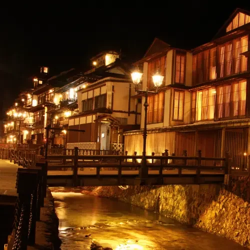 Ryokan de montagne dans les Alpes japonaises Ryokan traditionnel illuminé dans une station thermale japonaise de montagne.