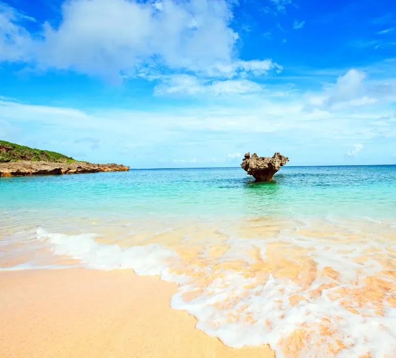 Plage de sable clair bordée d’une mer turquoise dans l’archipel d’Okinawa.