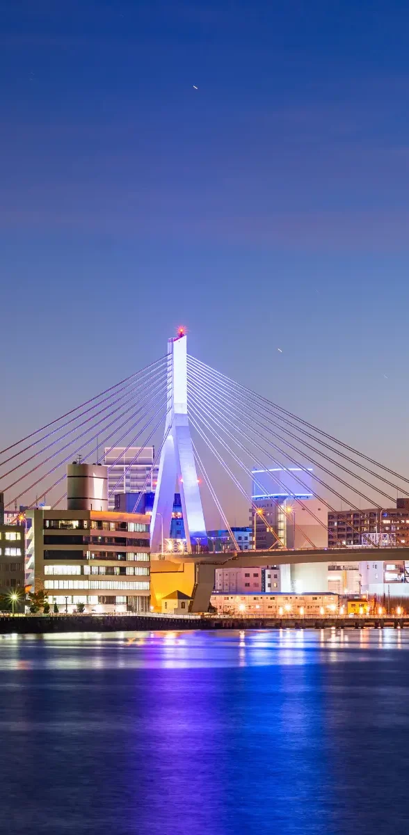 Vue de la baie d’Aomori avec pont illuminé et ville au coucher du soleil au Japon