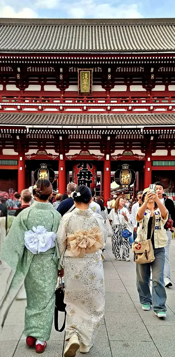 Visiteurs en kimono devant le temple Sensō-ji à Asakusa, Tokyo Deux visiteurs en kimono traditionnel japonais marchant devant le temple Sensō-ji dans le quartier historique d’Asakusa à Tokyo.