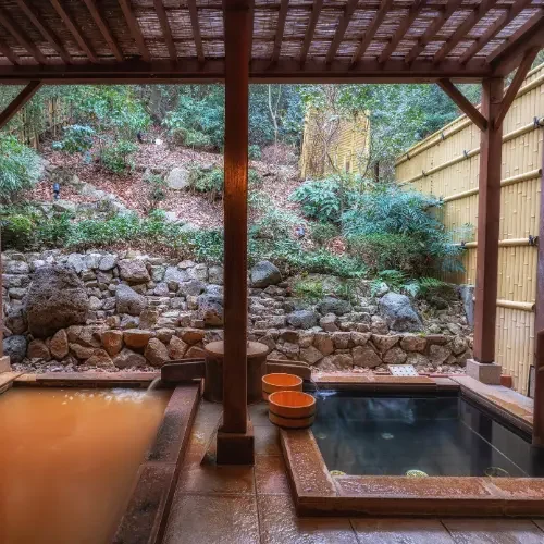 Ryokan avec onsen privé au Japon Onsen extérieur dans un ryokan traditionnel japonais entouré de nature.